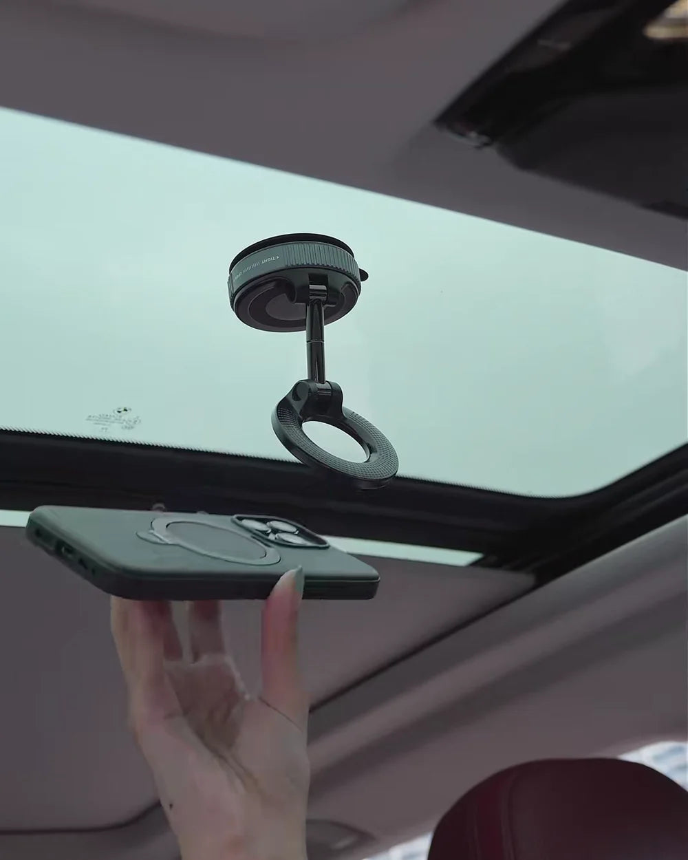 Soporte magnético sujetando el celular en el techo de vidrio del carro